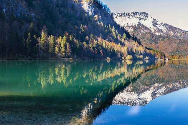 modrá hladina rakouského jezera s odrazem hor